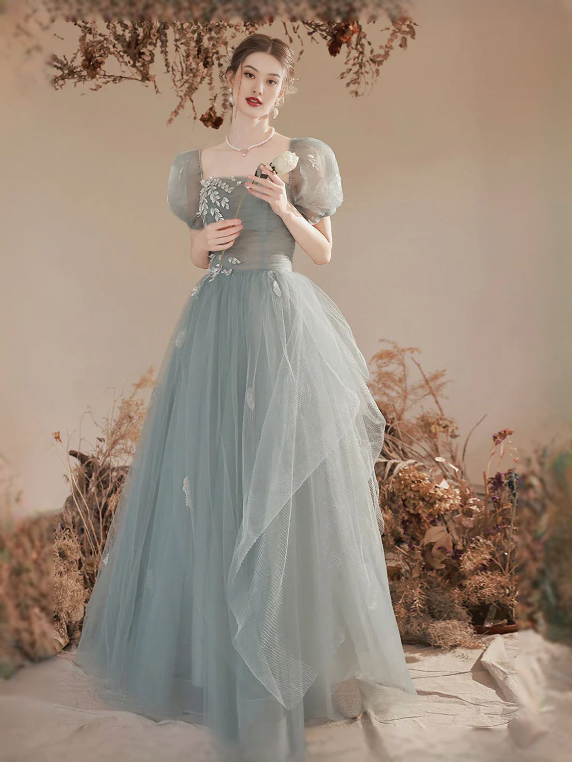 Front-facing mist blue A-line tulle maxi with floral ruched corset and square neckline, puff sleeves
