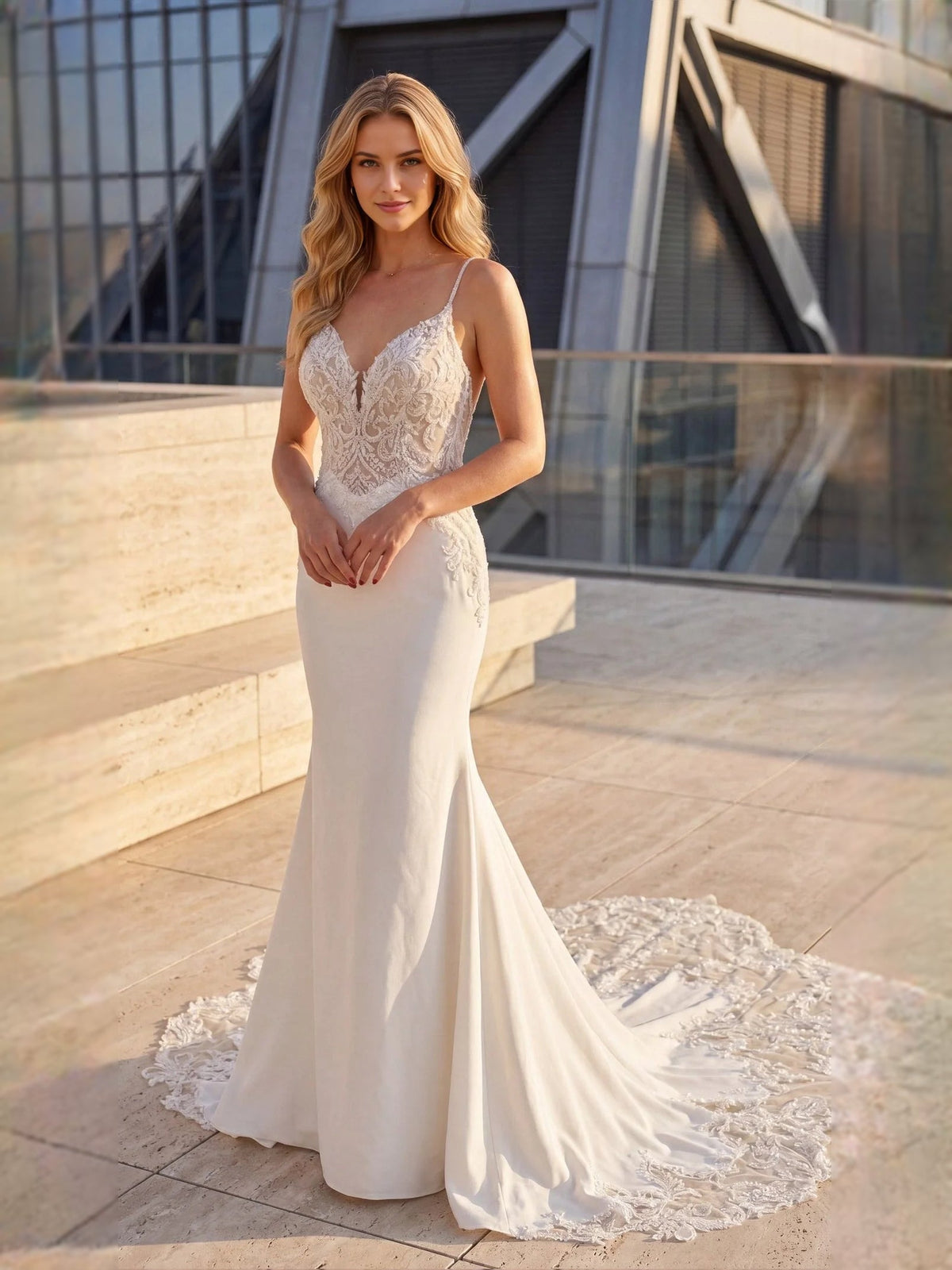 White lace mermaid wedding dress with spaghetti straps and sweeping floor-length train