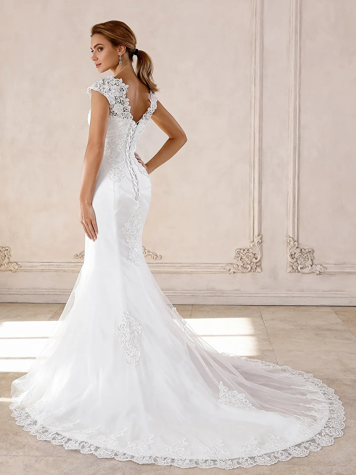 Ivory embroidered mermaid wedding dress with cap sleeves and flowing tulle hem