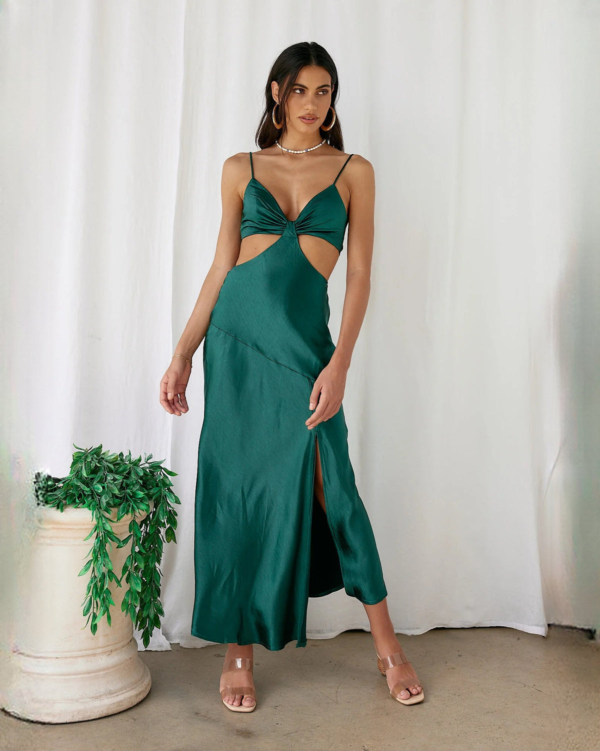 Emerald green satin sleeveless maxi dress with sweetheart twist bodice and front side slit.