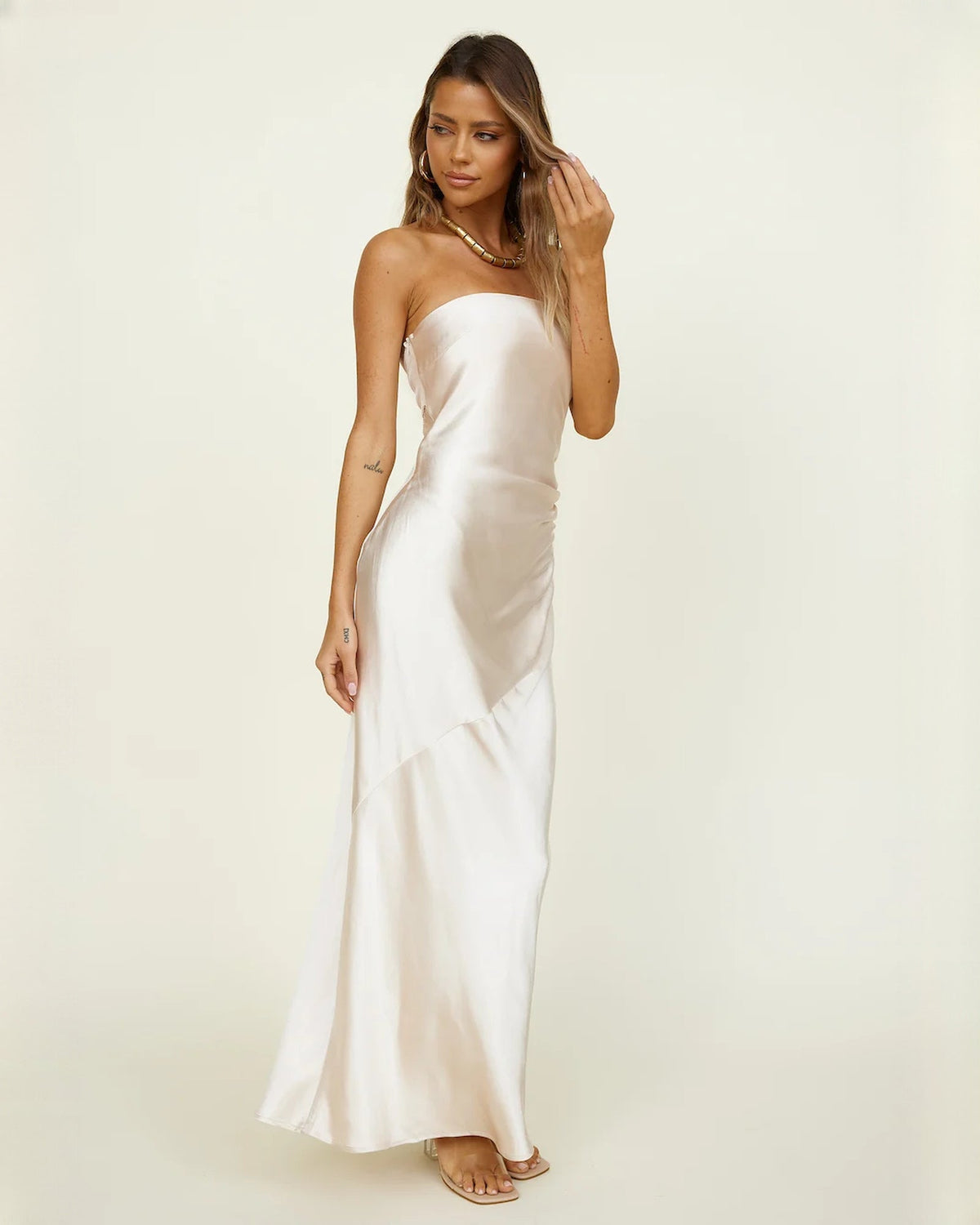 Ivory satin A-line maxi bridesmaid dress with sleeveless bodice and flowing tiered skirt