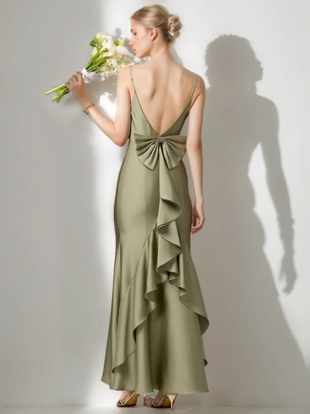 Dusty sage satin gown with open back bow and layered ruffle skirt.