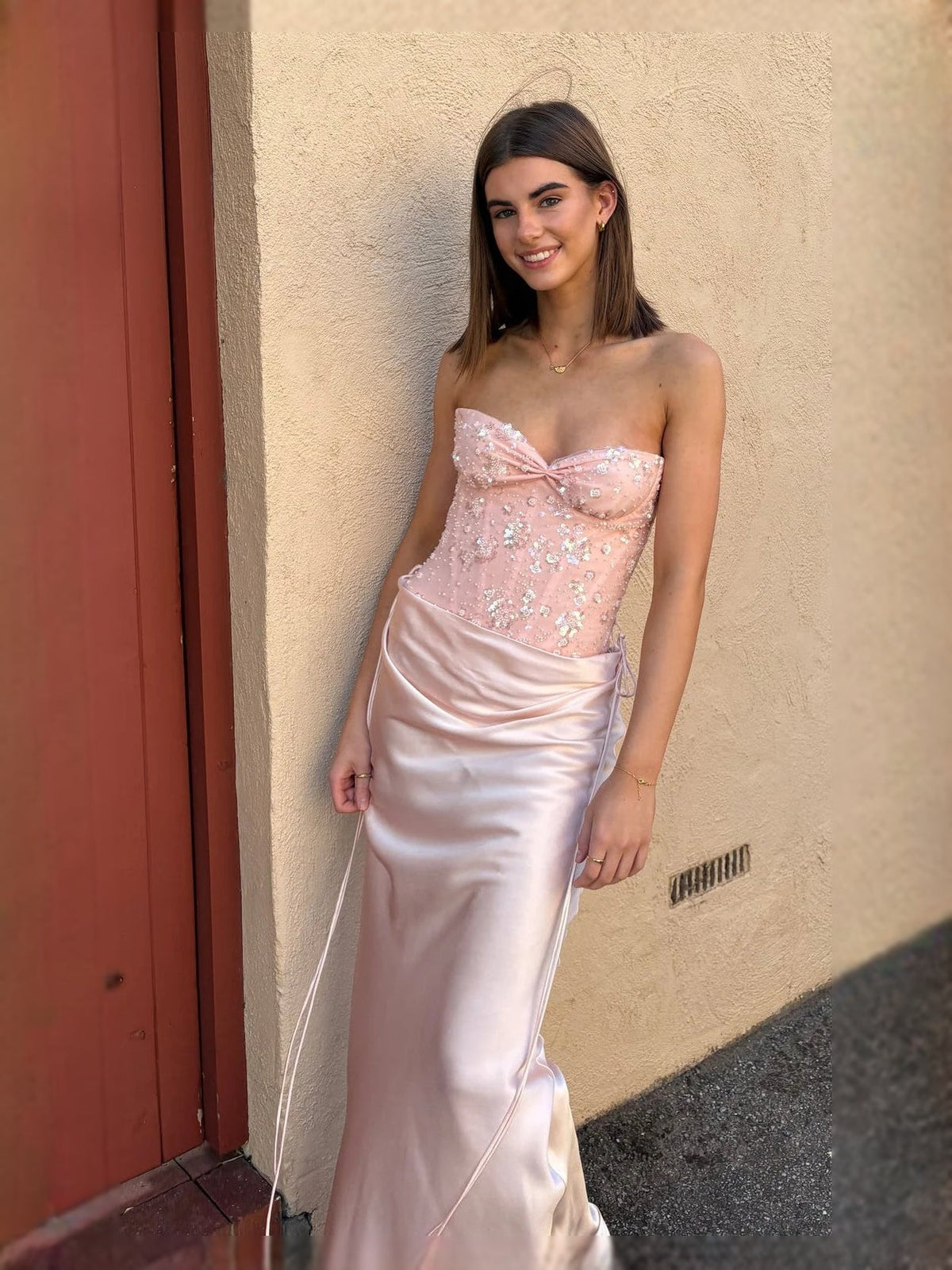 Light pink strapless corset prom dress with sweetheart neckline, sequin bodice, draped skirt