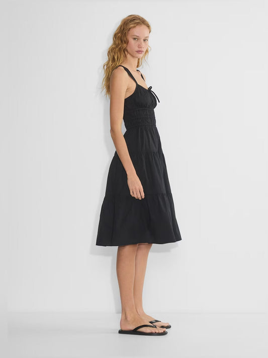 Black tiered midi dress with spaghetti straps and bow, smocked bodice, tiered skirt