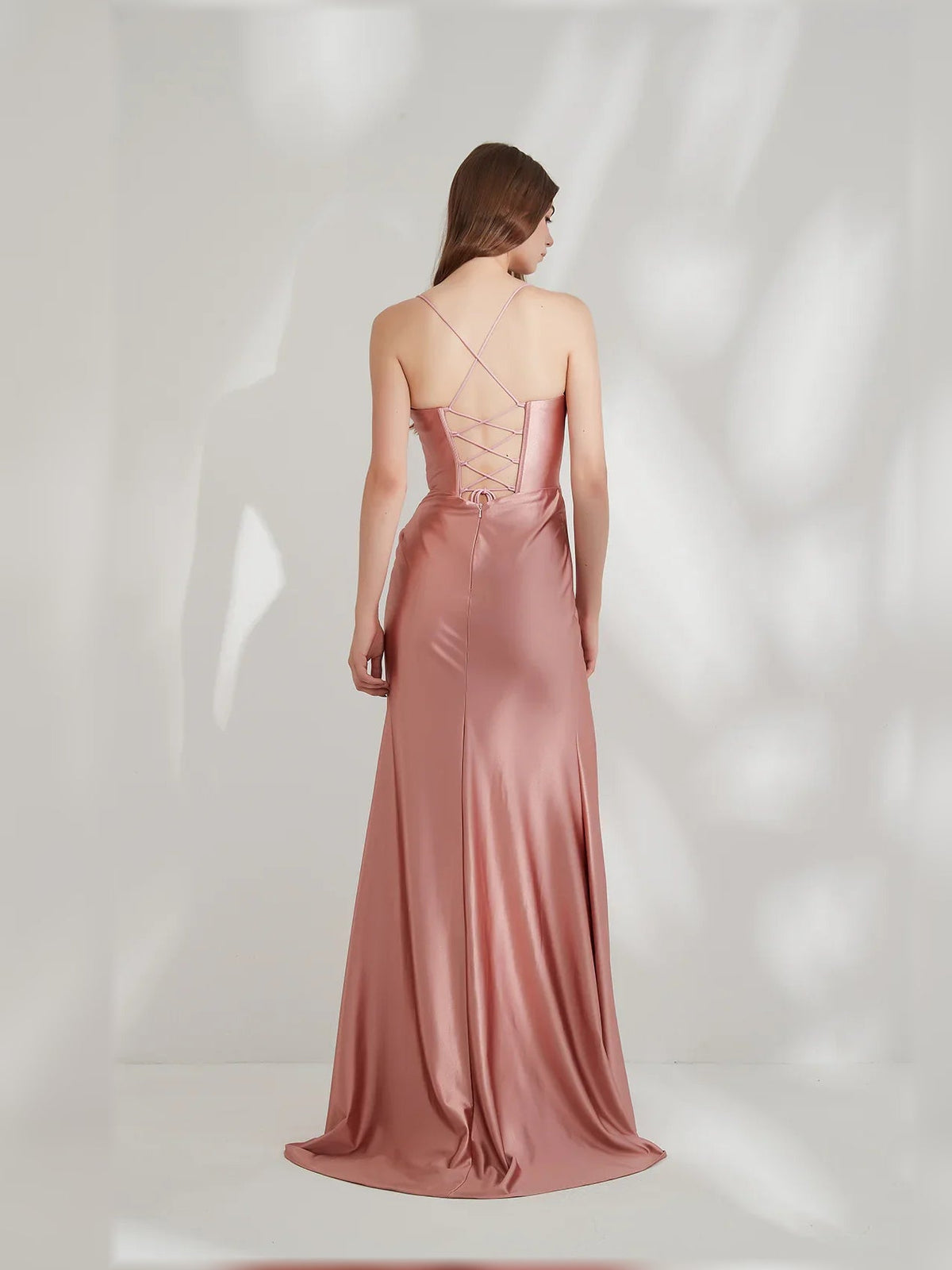 Rose gold cowl-neck corset formal dress with open back and crisscross straps, slit