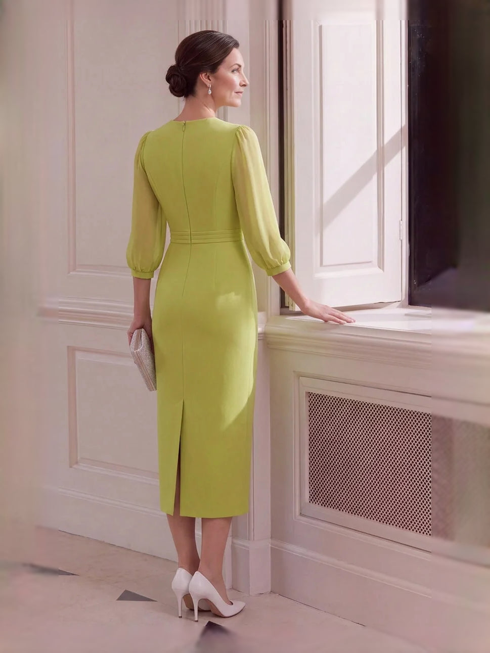 Chartreuse V-neck sheath midi dress with back slit detail, standing side view.