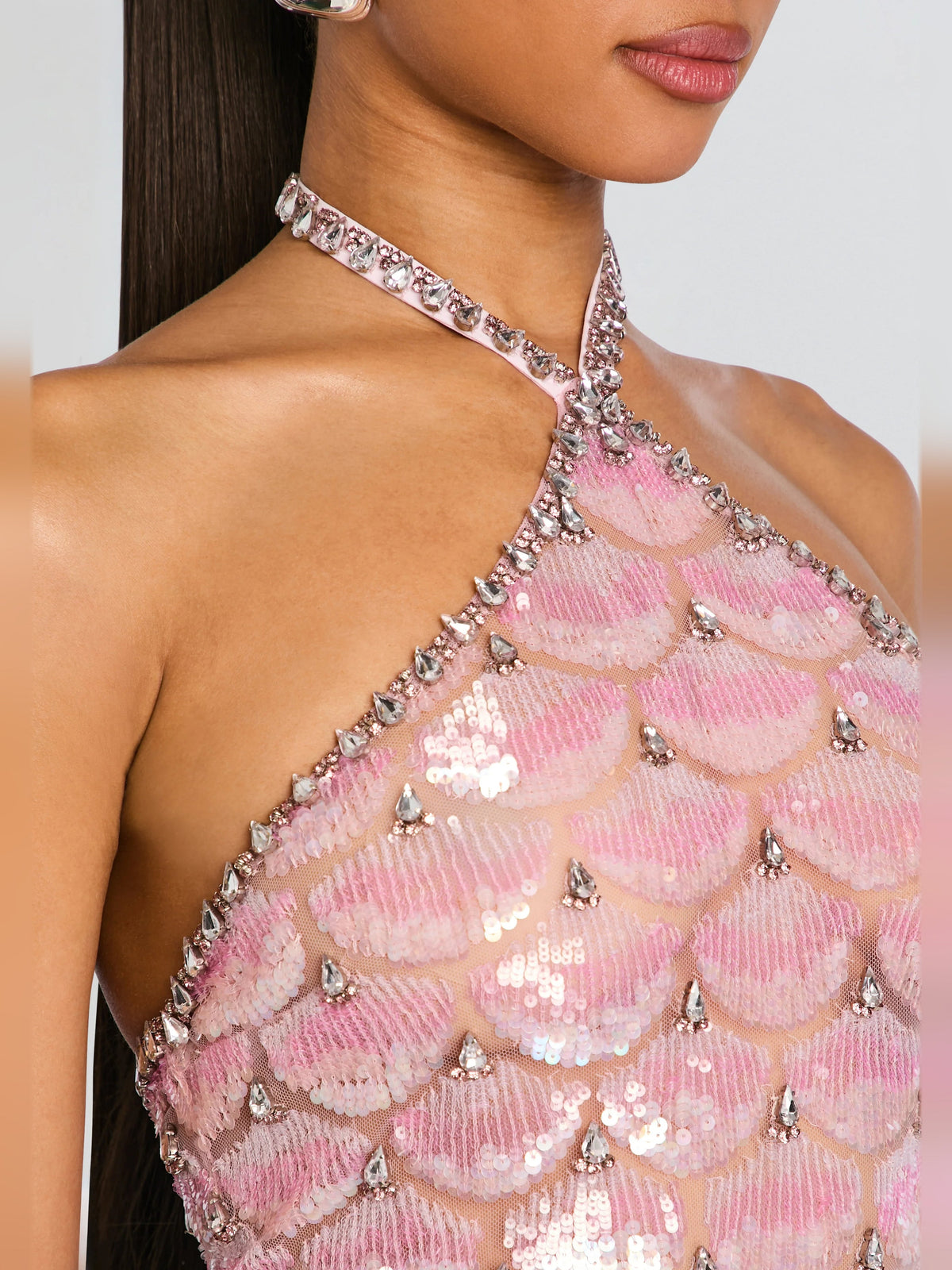 Close-up of pink sequin halter mini dress with beaded neckline and scalloped pattern.