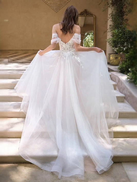 Ivory tulle A-line wedding dress with corset back and flowing ruffled bodice