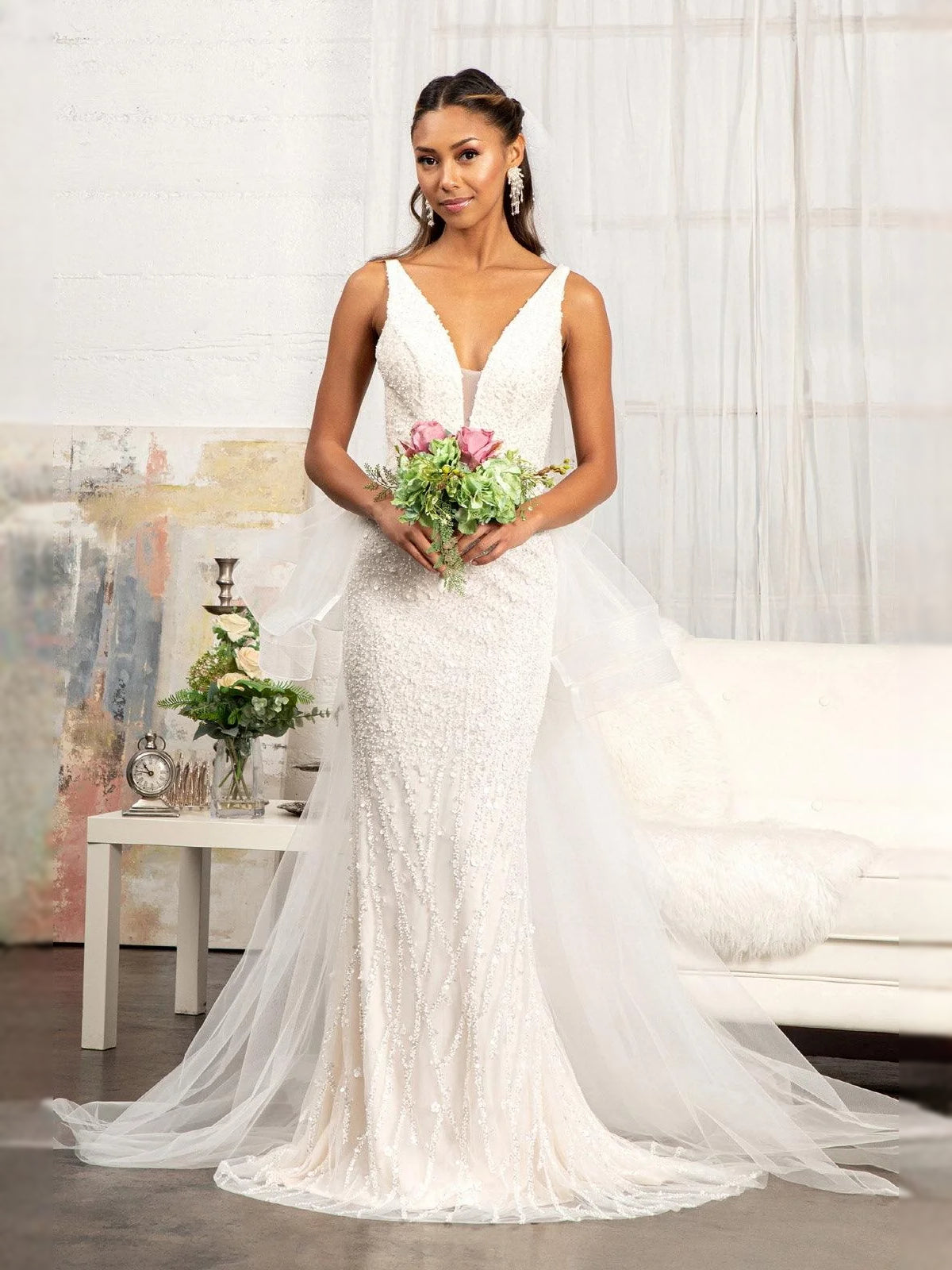 Ivory V-neck mermaid wedding dress with sequined bodice and voluminous layered tulle train