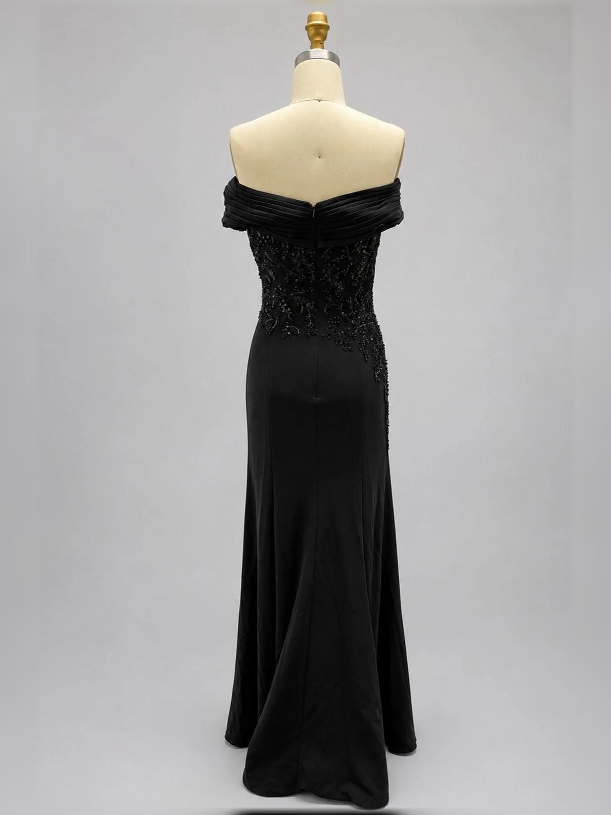 Black off-shoulder mermaid gown on mannequin, ruched neckline, embellished bodice, side slit