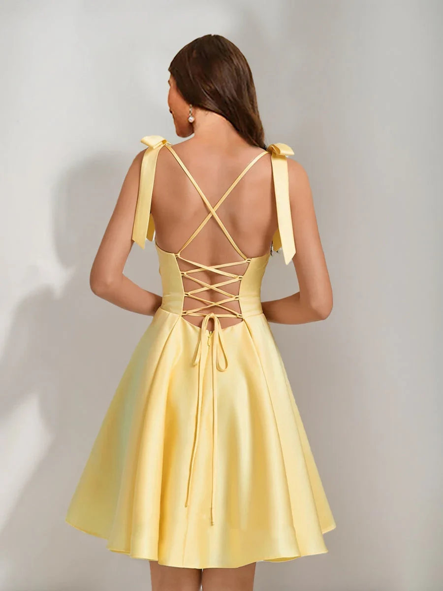 Back view of yellow satin A-line short dress with crisscross lace-up and bow ties.