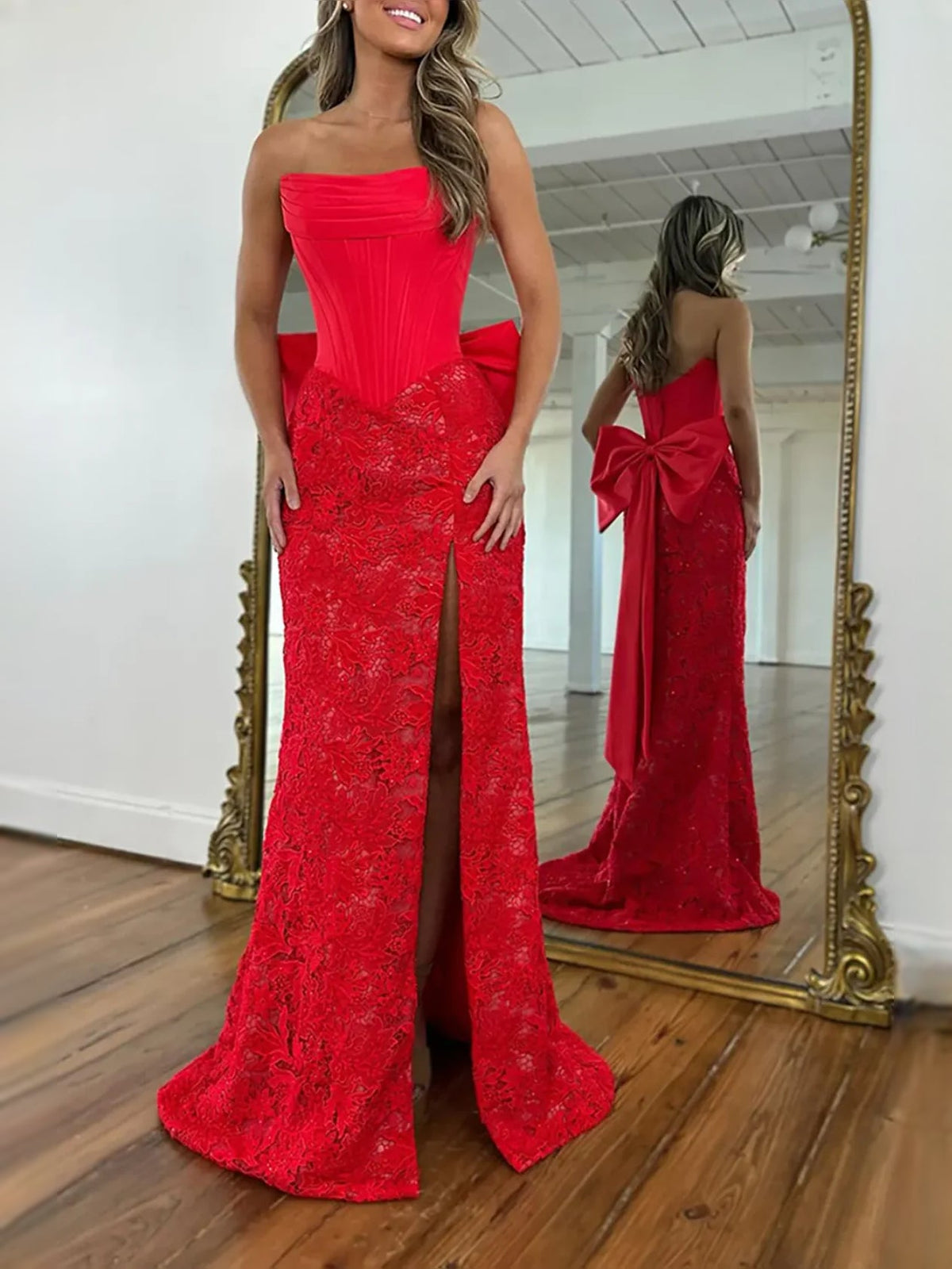 Red strapless mermaid prom dress with corset-style bodice, lace overlay, and back bow