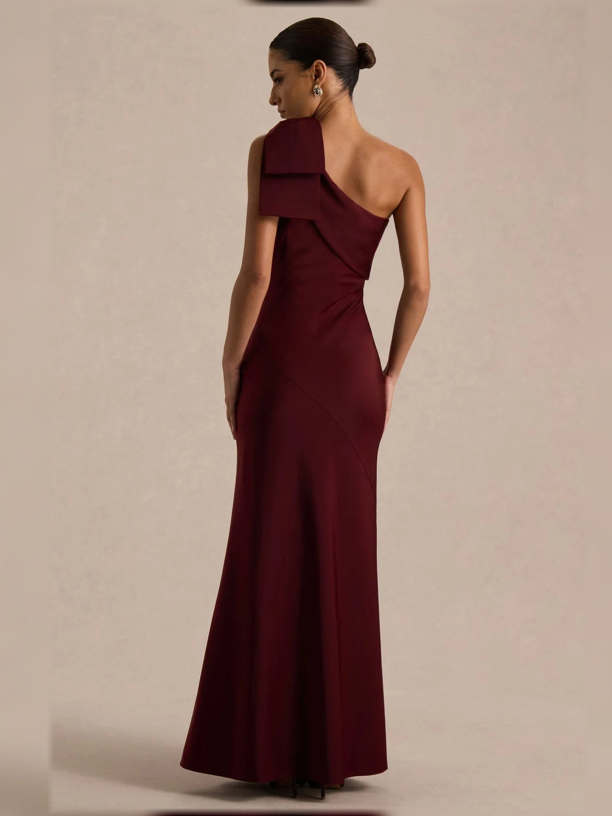 Burgundy one-shoulder satin mermaid dress with folded shoulder bow, side view