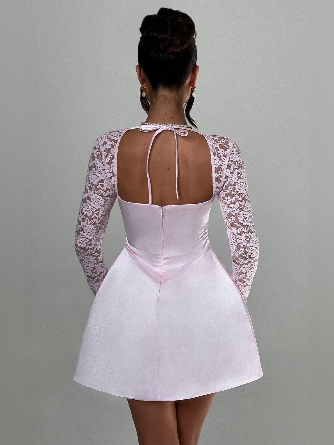 Blush mini dress with long lace sleeves and open back with thin tie straps