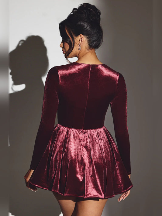 Wine velvet mini dress, back view: long sleeves and flared skirt with ruched waist.
