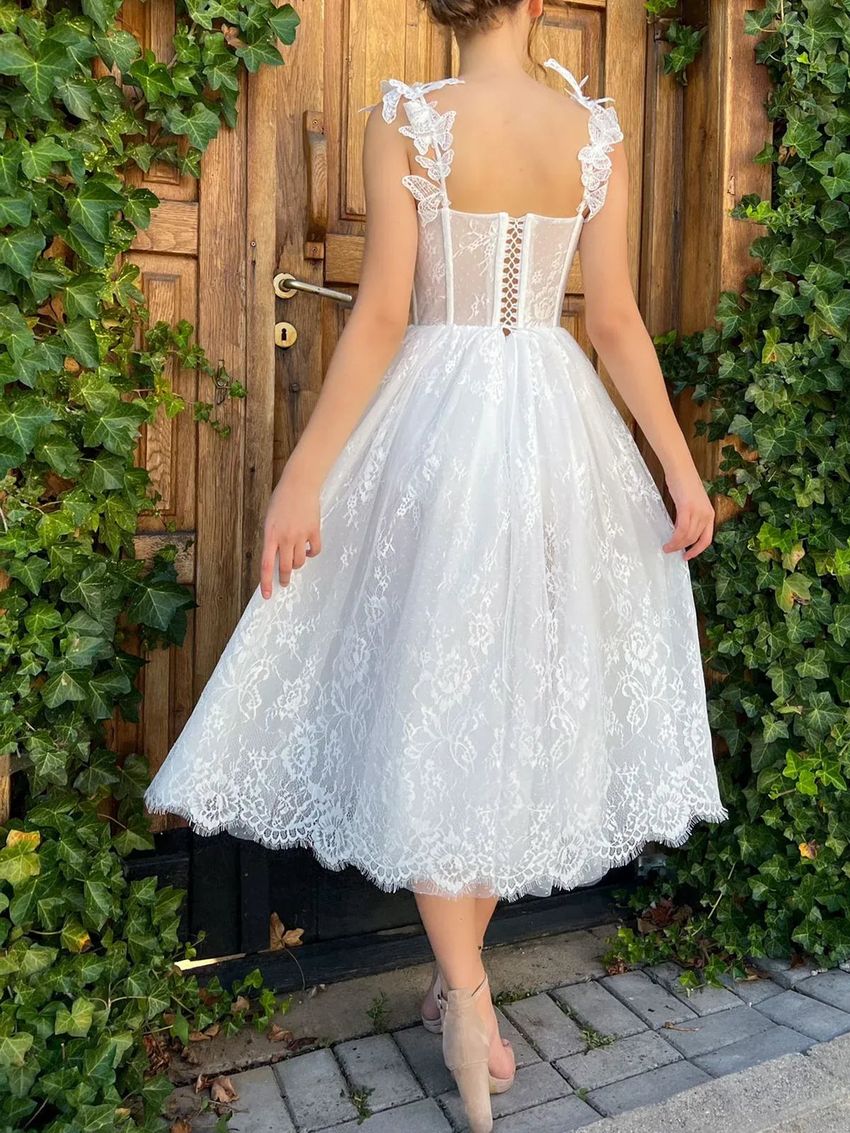 White lace tea-length corset dress with corset back detail and bow-trim spaghetti straps