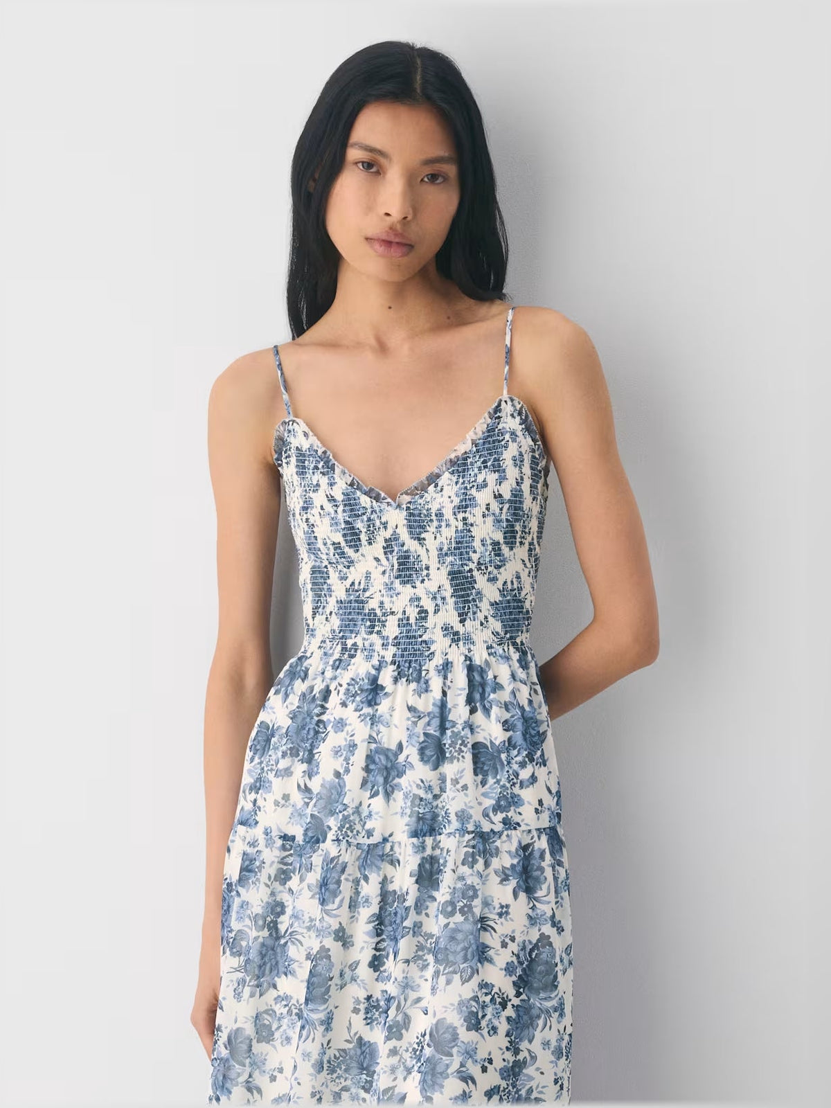 Blue and white floral tiered midi dress with V-neckline and thin spaghetti straps