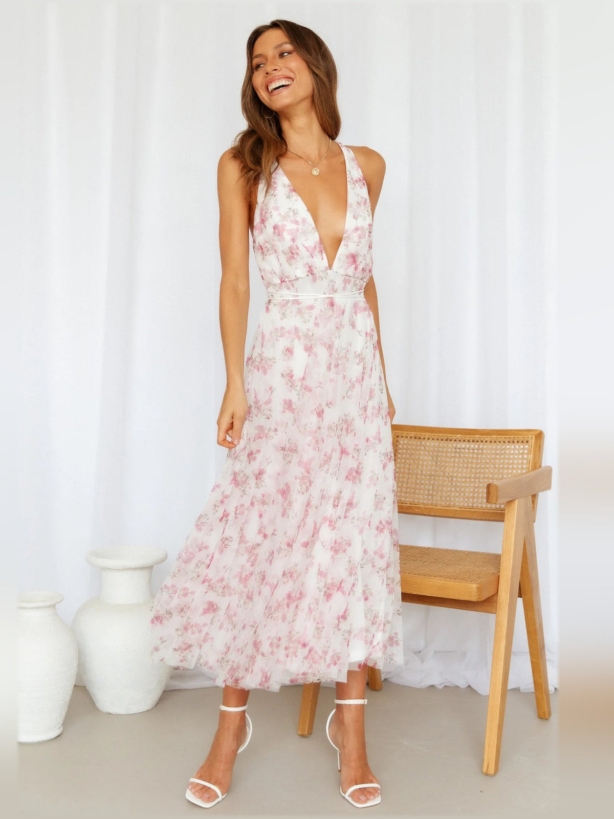 Pink floral midi dress with deep V-neck, spaghetti straps, flowing tiered skirt
