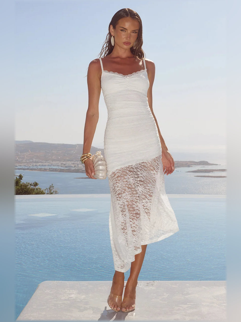 White midi dress with thin straps and ruched bodice, lace overlay asymmetrical hem