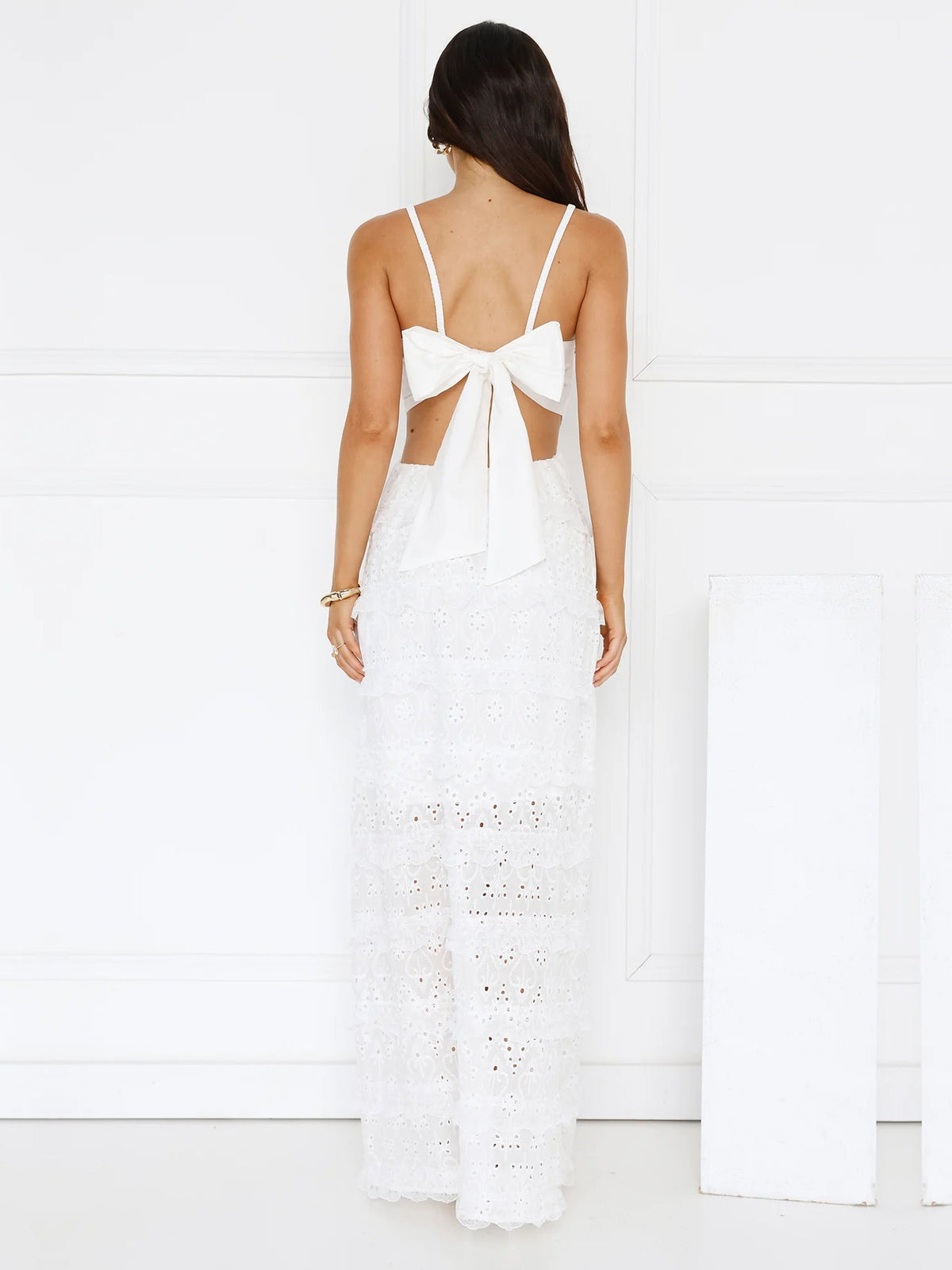 White a-line maxi formal dress with tiered skirt, full-length back view
