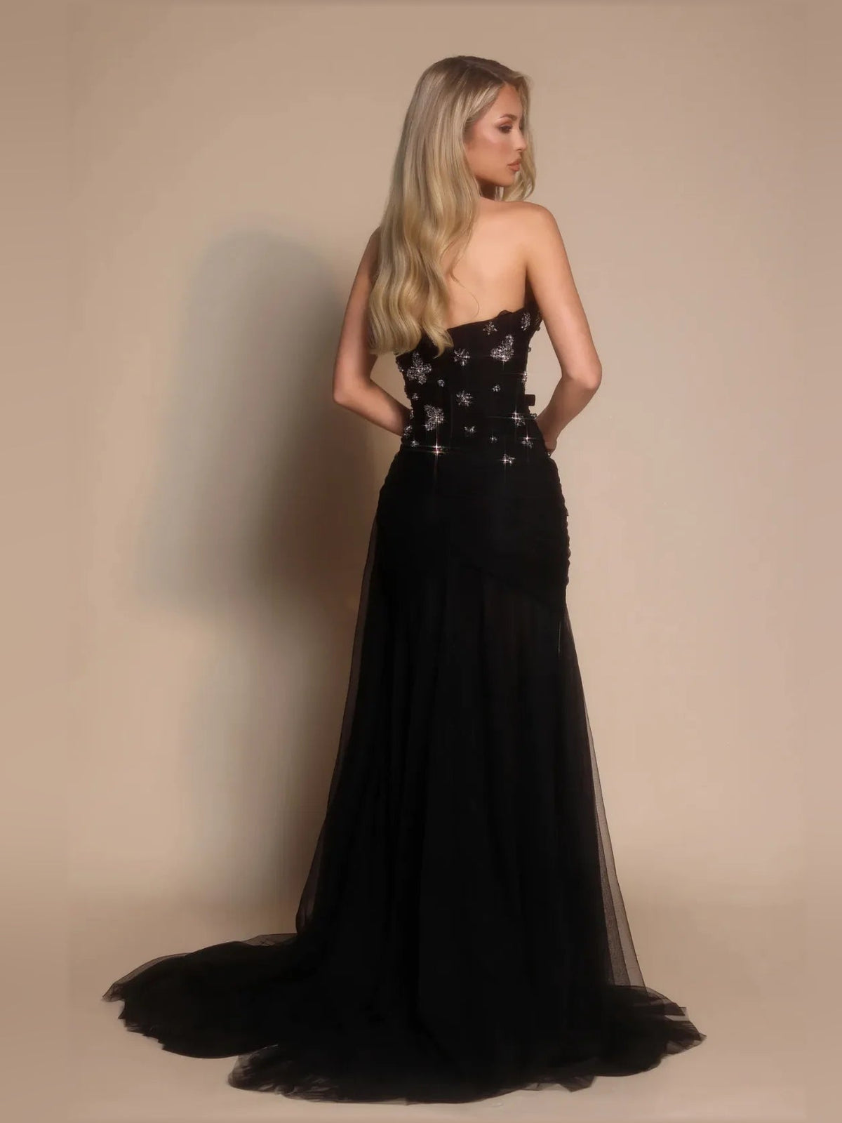 Black strapless formal dress from back view with rhinestone floral bodice and tulle hem