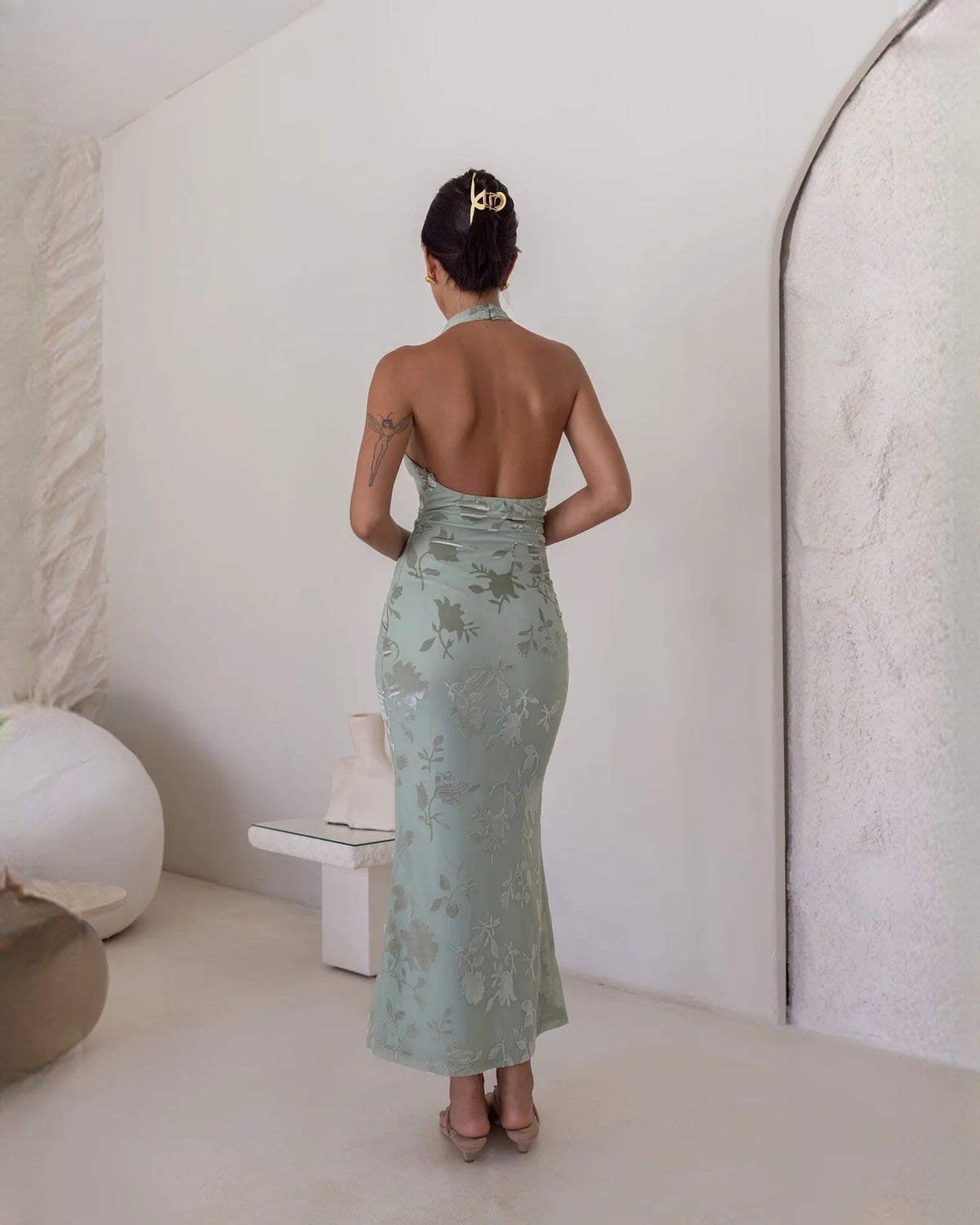 Back view of dusty sage floral sleeveless halter A-line maxi dress