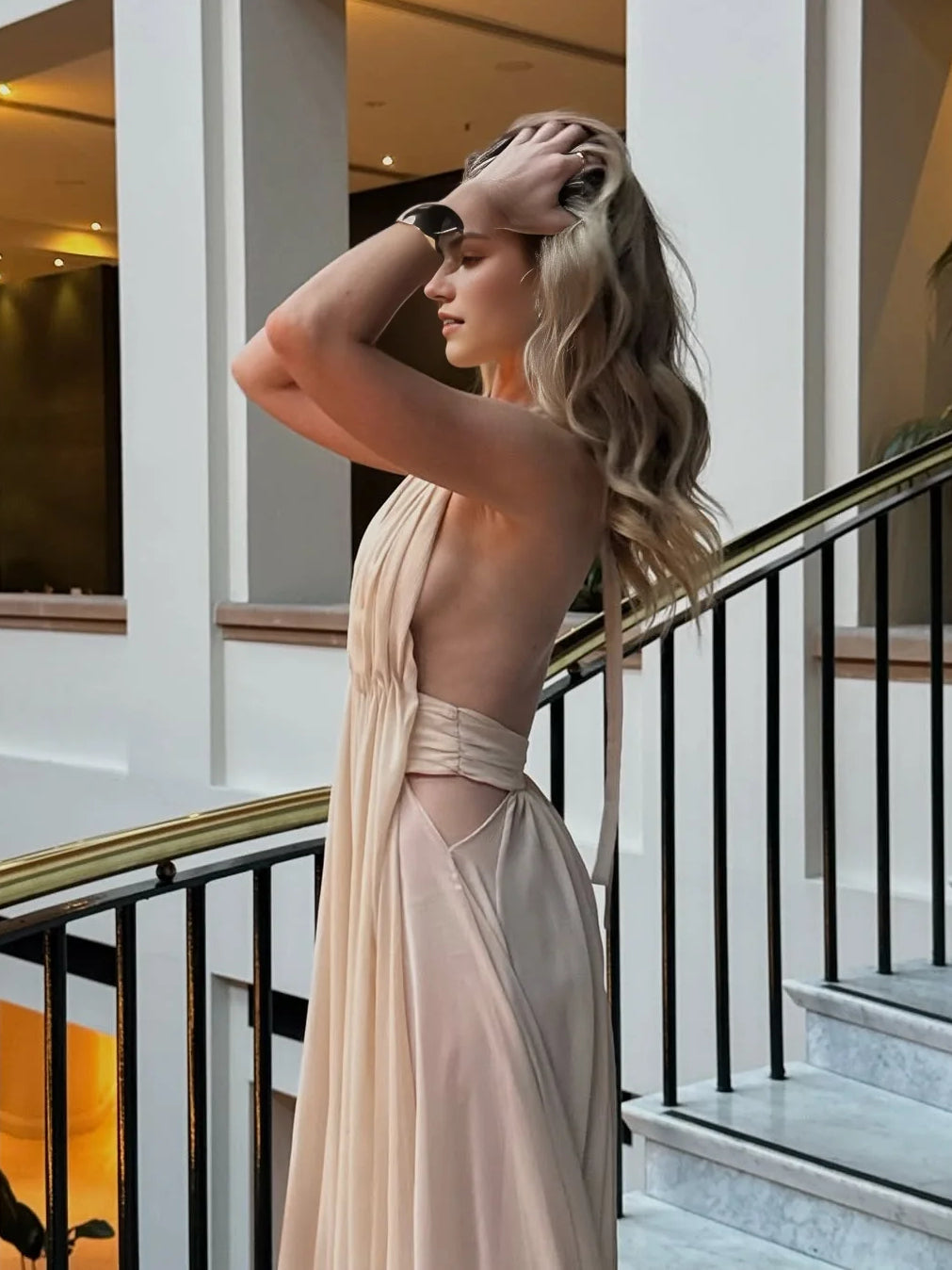 Champagne halter maxi dress with open back cutout and draped fabric