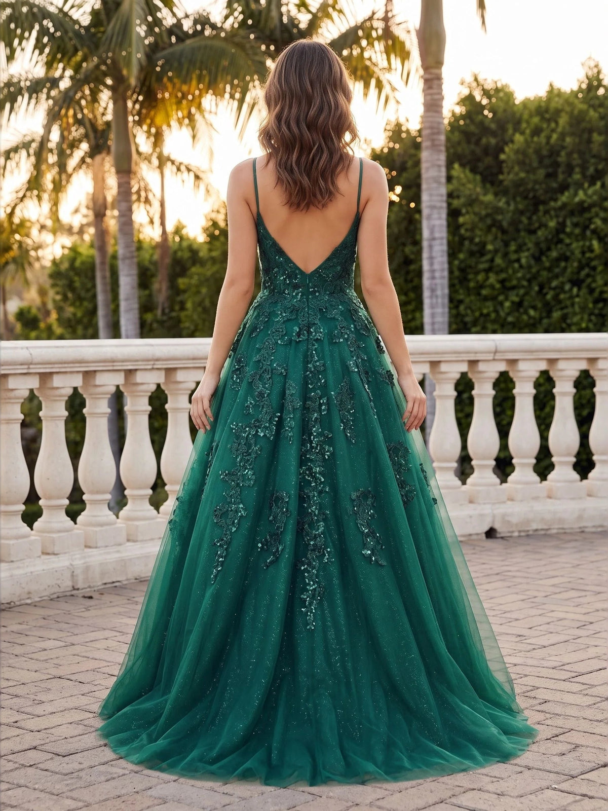Back view of emerald green sequin A-line prom dress with V-back and floral tulle skirt
