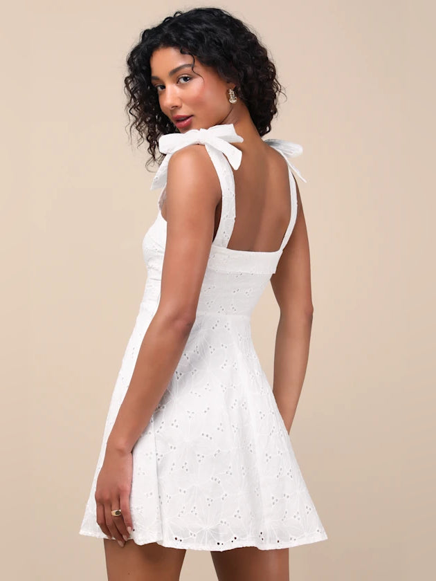 White embroidered mini dress with open back and bow shoulder ties