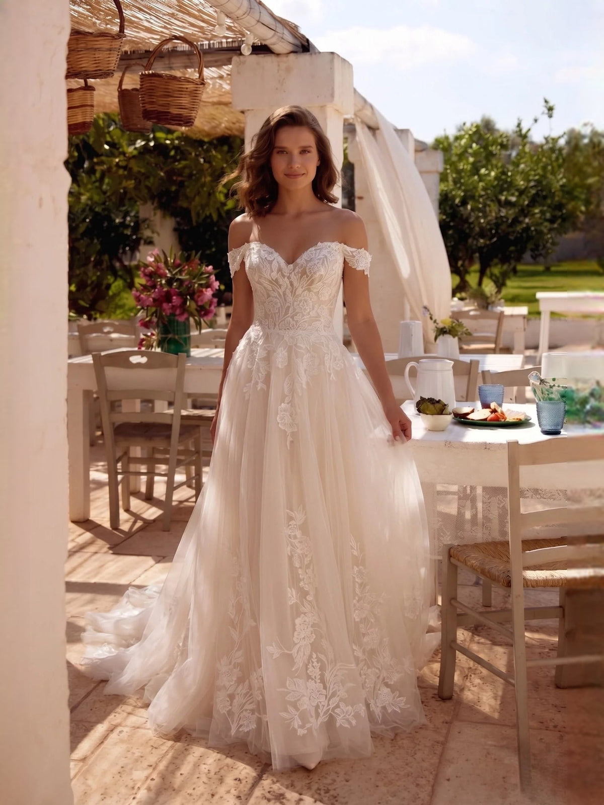 Ivory off-shoulder wedding dress with floral lace bodice and flowing tulle A-line skirt