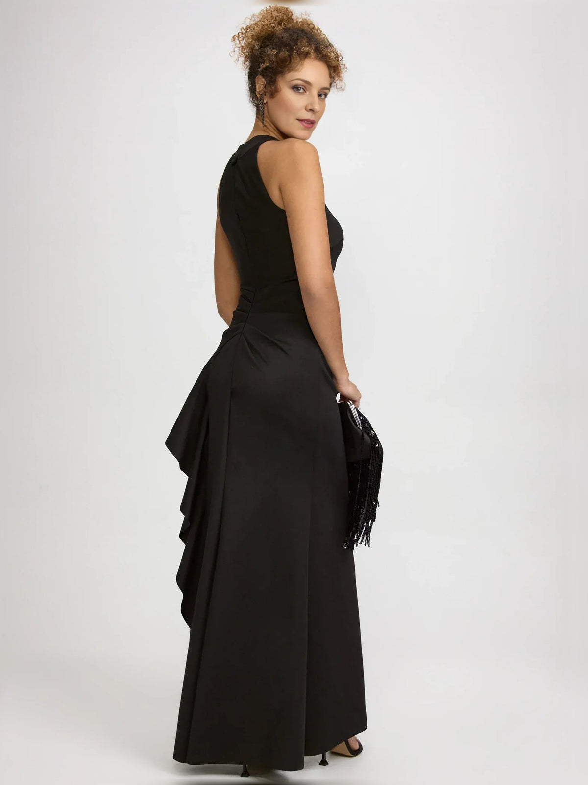 Black halter-neck formal dress with ruffled skirt and side slit, full-length