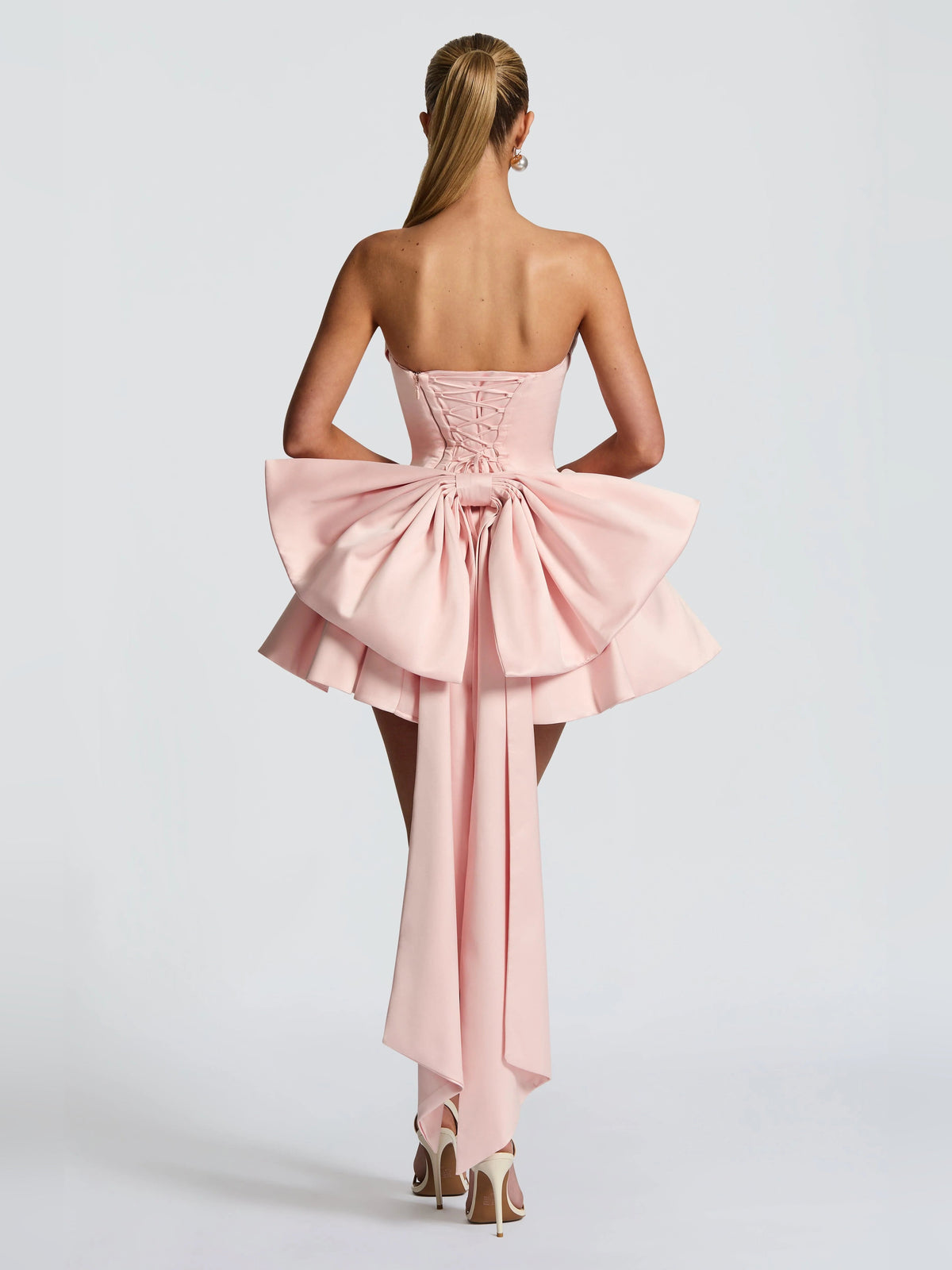 Blush strapless mini dress with corset-back detail and gathered bow at the waist