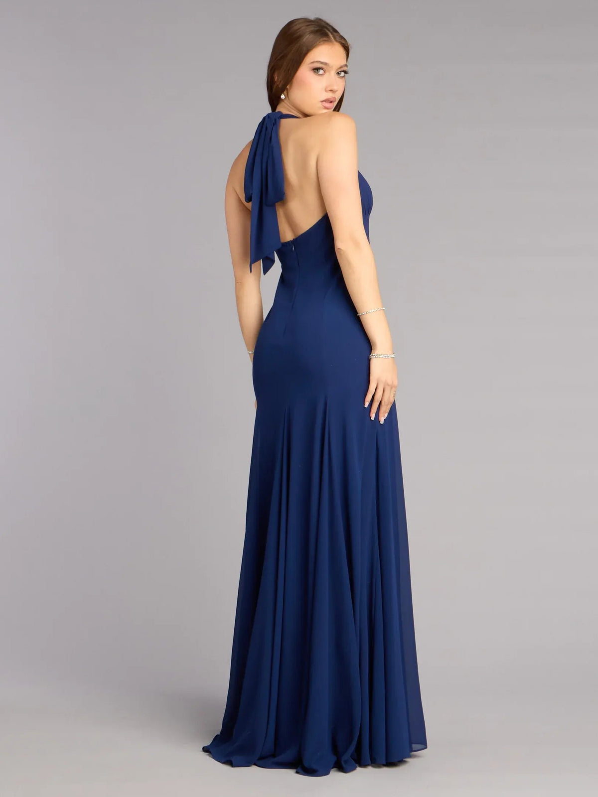 Dark navy halter open-back A-line gown with draped back and pleated skirt