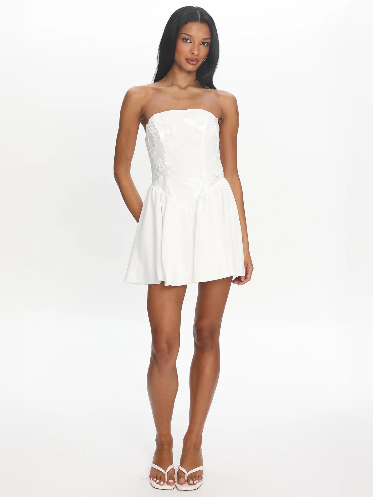 White strapless mini dress with gathered waist and flowing A-line skirt