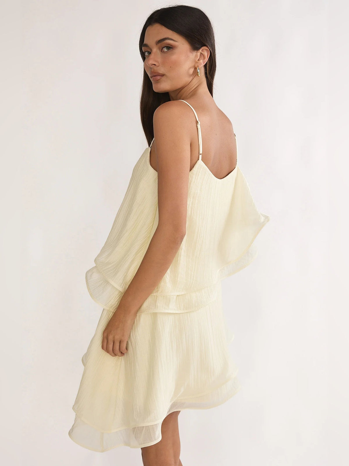 Cream mini dress side view with spaghetti straps and tiered ruffle overlay
