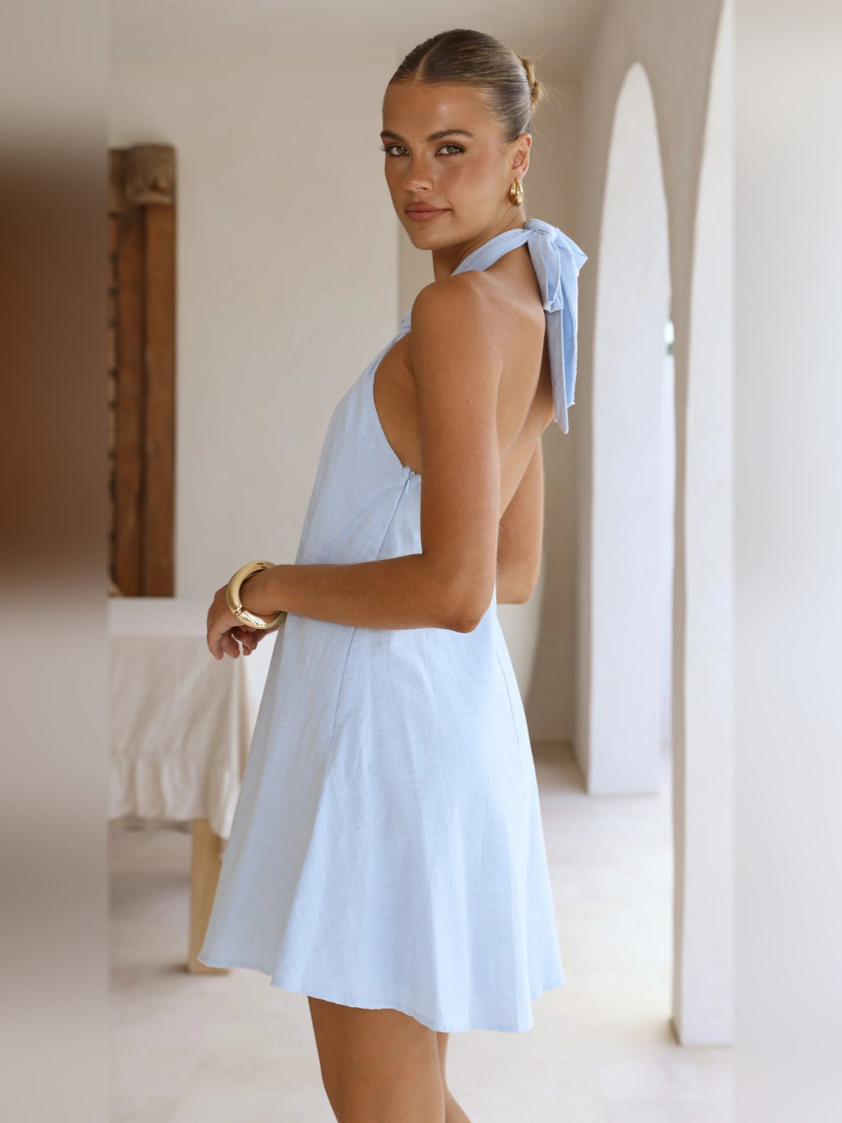 Light blue halter mini dress, open back with tie-neck detail and flared hem