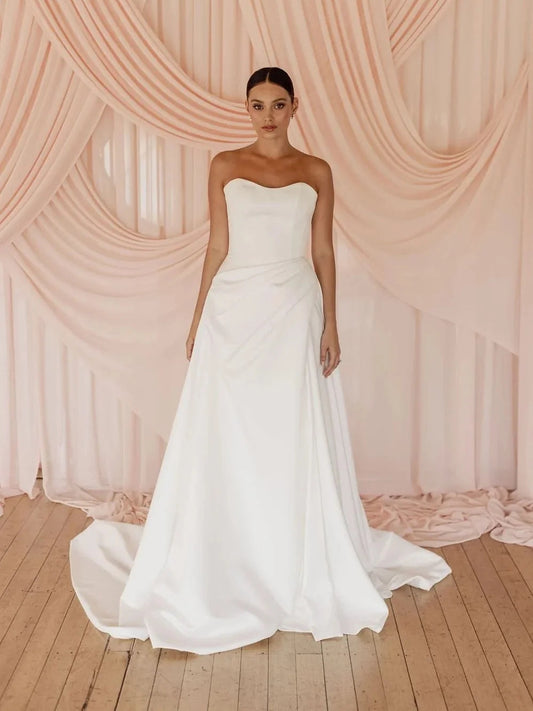 Ivory satin strapless sweetheart corset ballgown with fitted waist and pleated full skirt