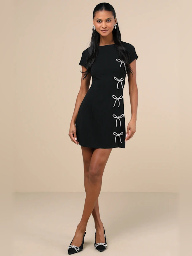 Black mini cocktail dress, short sleeves, front bow rhinestone trim, A-line silhouette