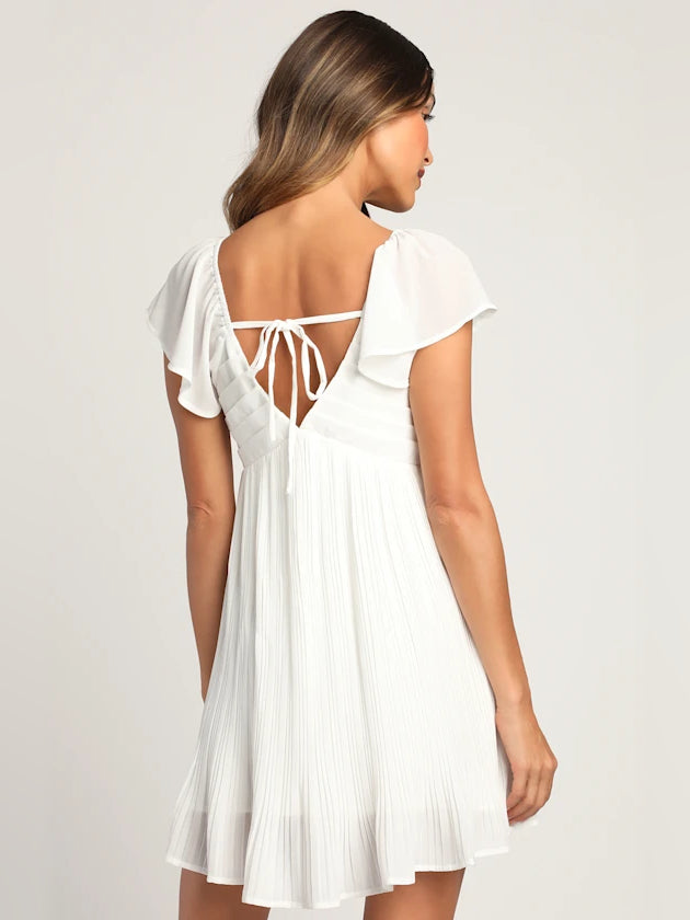 White pleated mini dress with open back and lace-up tie, flutter sleeves
