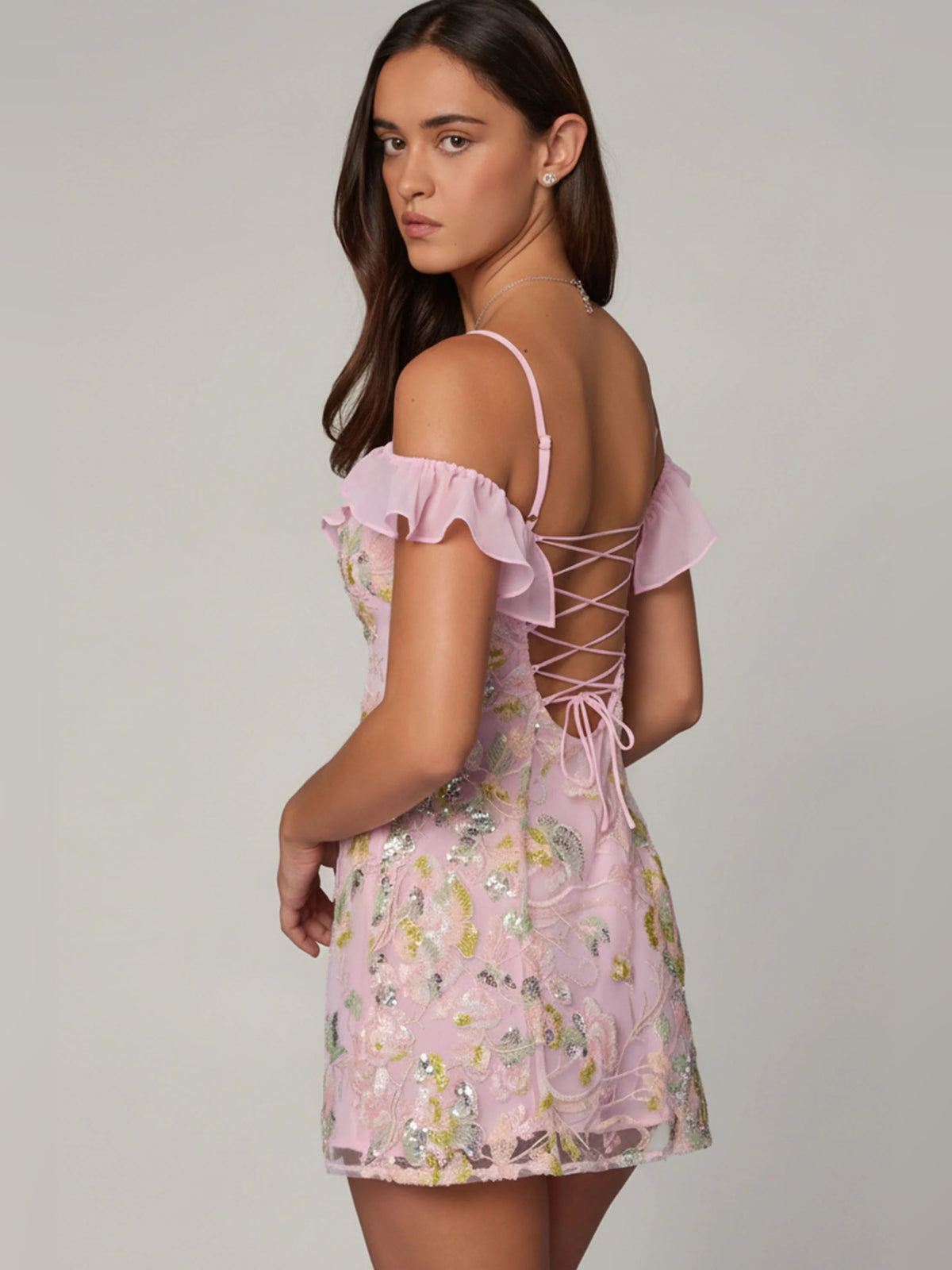 Pink A-line mini dress with ruffled off-shoulder front and lace-up crisscross back