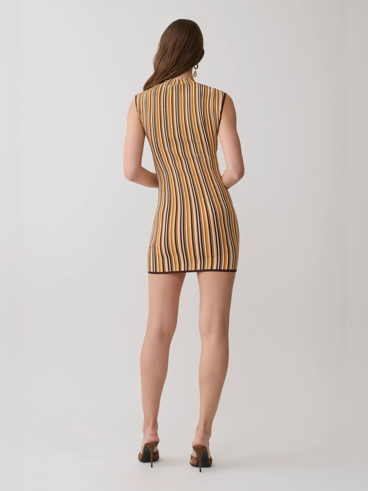 Back view of sleeveless mini dress with vertical stripes in brown, cream, and dark accents