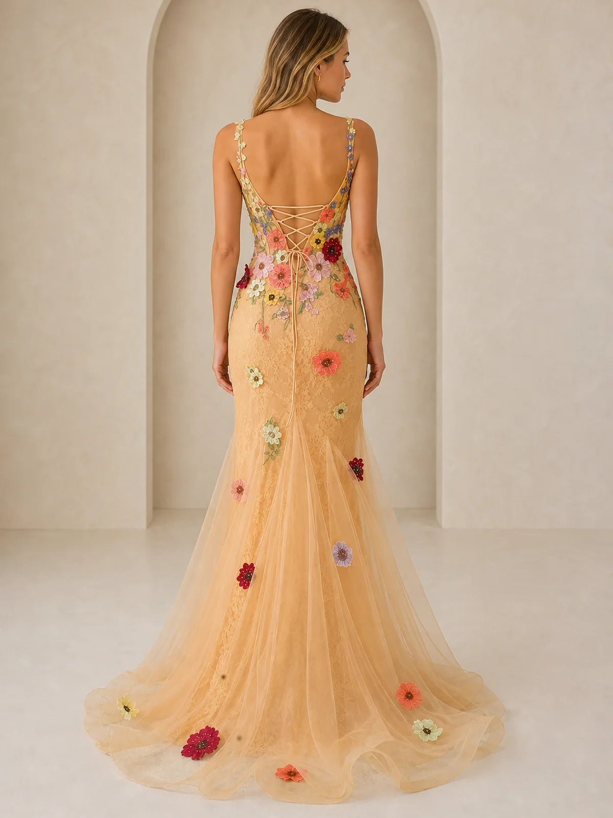 Back view of peach tulle mermaid prom dress with floral appliques and open-back straps