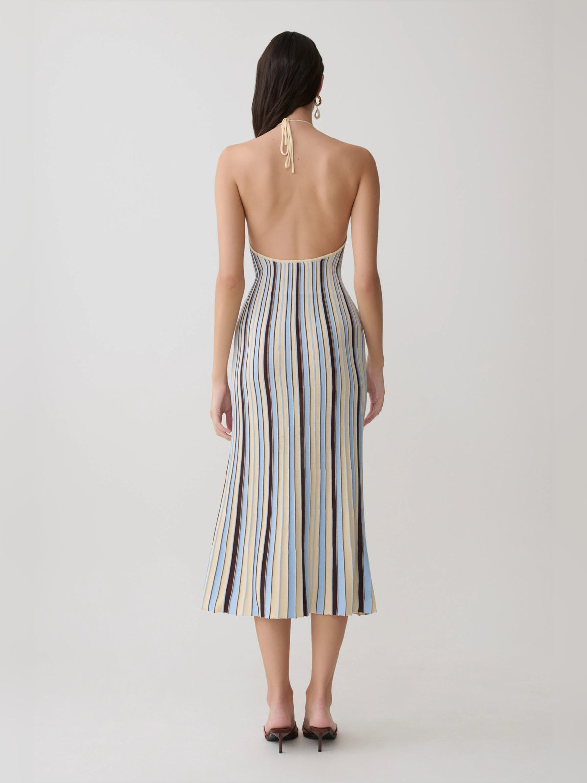 Back view of halterneck knit midi formal dress with vertical cream, blue, and brown stripes.
