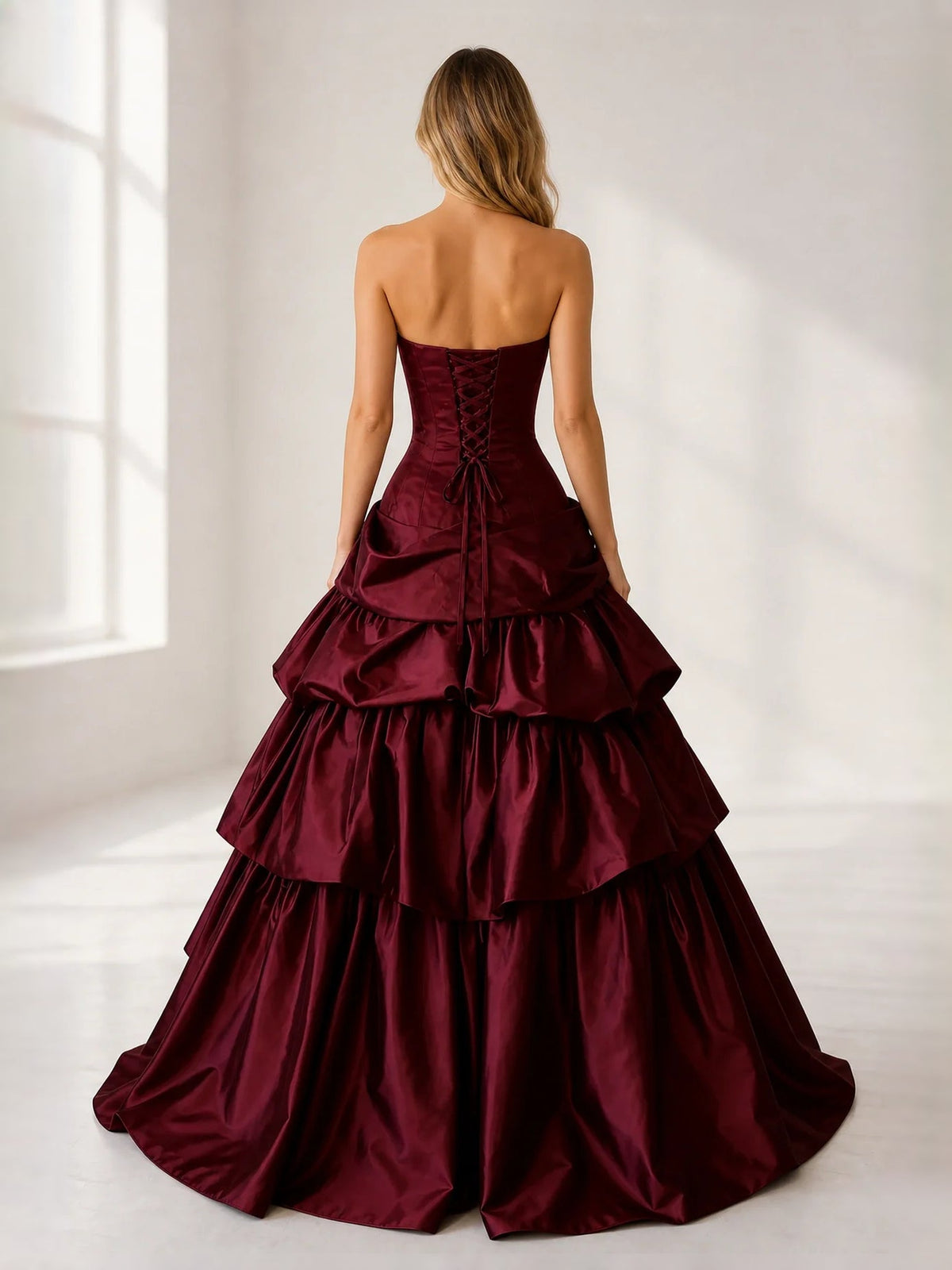 Burgundy satin strapless corset ball gown with tiered ruffle skirt, back view