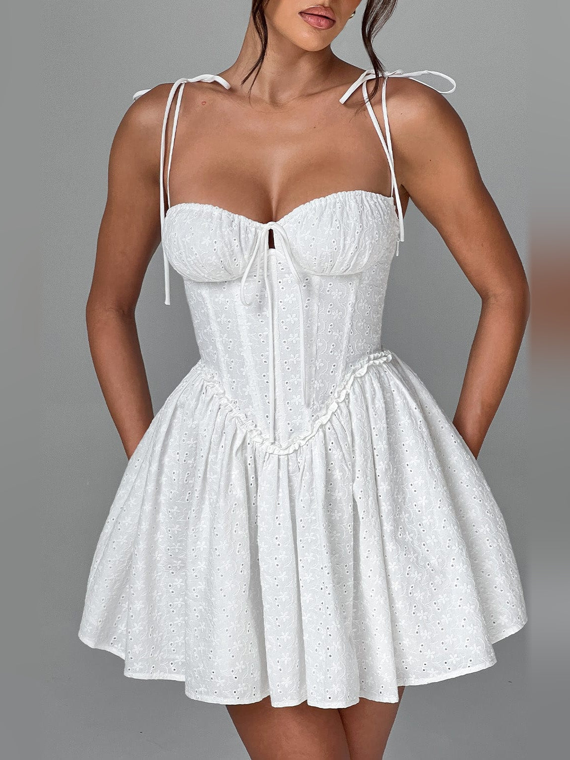Ivory mini dress with sweetheart corset bodice, thin tie straps, and flared tiered skirt