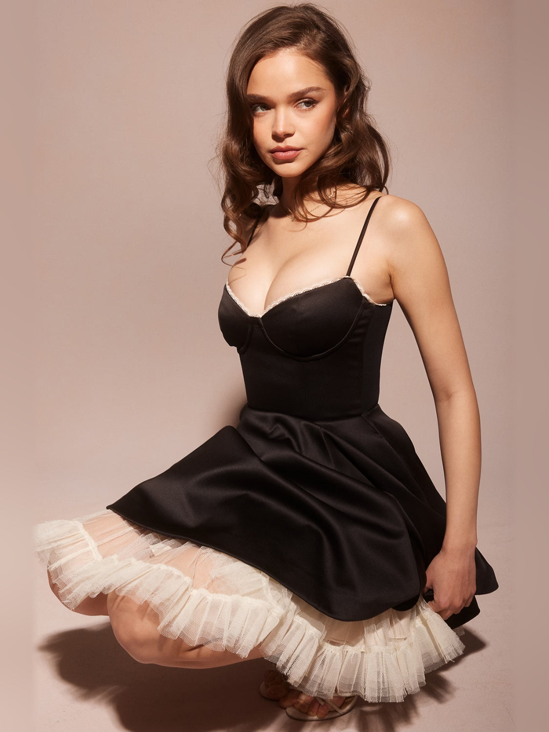 Black mini dress with sweetheart neckline, thin straps, and ruffled tulle skirt overlay
