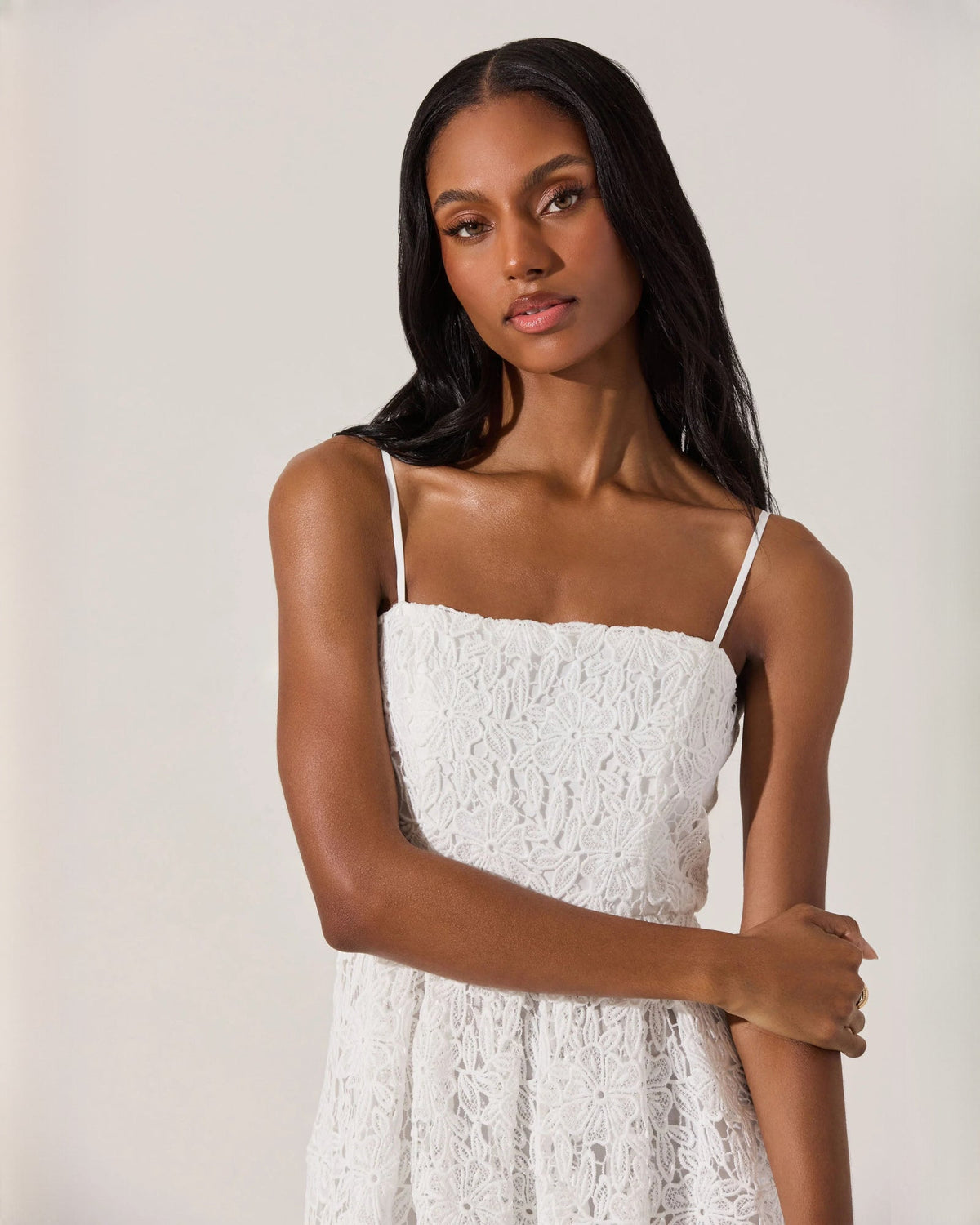 Close-up of white sleeveless dress bodice with spaghetti straps and textured lace