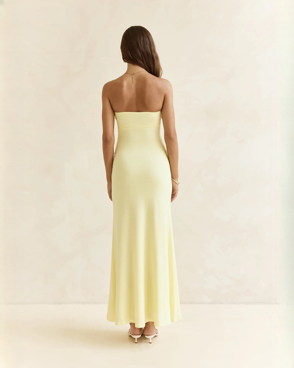 Light yellow strapless satin A-line maxi dress, open back view, draped waist detail