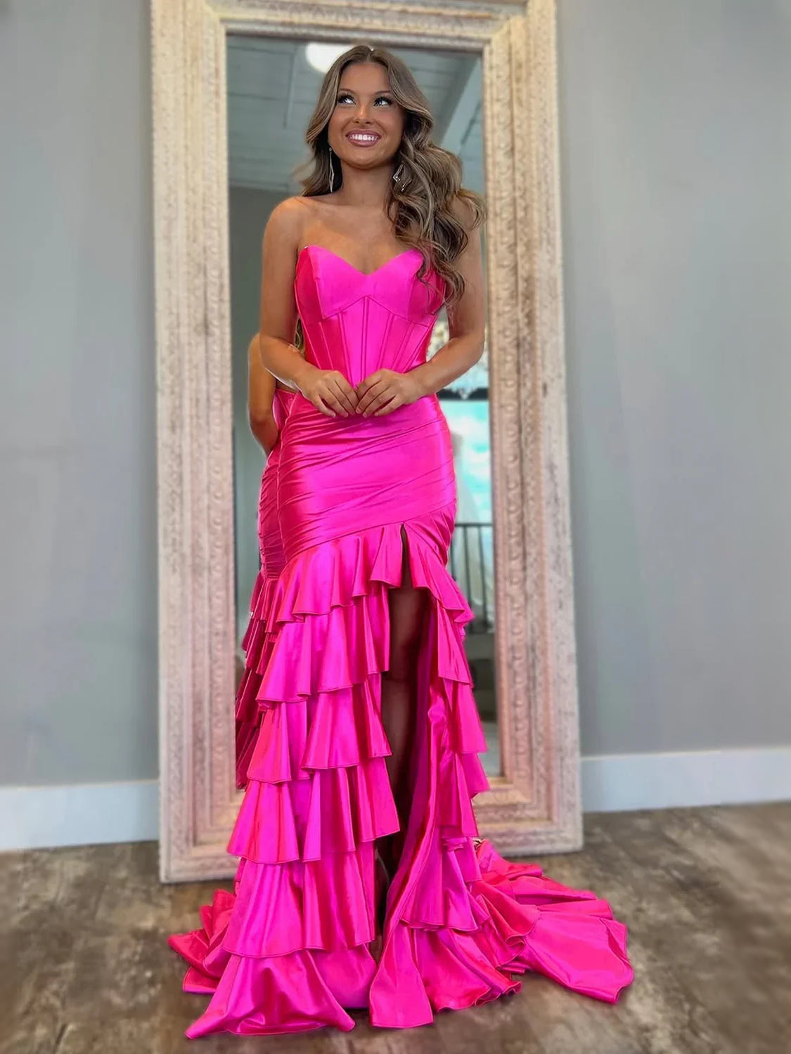 Fuchsia strapless mermaid prom dress with ruched corset bodice and tiered ruffle hem