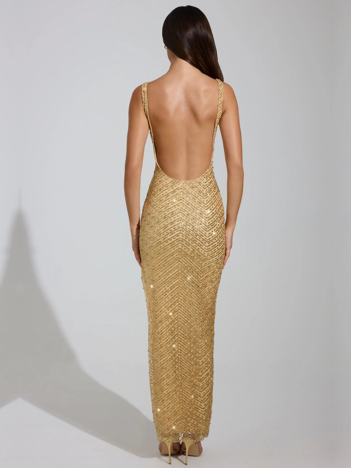 Gold sheath maxi formal dress with skirt slit, full-length back view